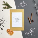 A festive holiday-themed flat lay featuring a 'Coming Soon' greeting card with decorative elements.